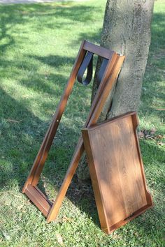 two wooden frames leaning against a tree in the grass