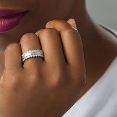 a woman wearing a wedding ring with three rows of diamonds on her finger and the other half of her hand