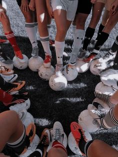 a group of soccer players standing in a circle with their feet on the ball while wearing socks