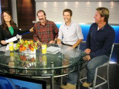 four people sitting around a glass table talking