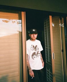 a man with tattoos standing in front of a door