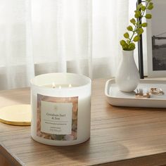 a white candle sitting on top of a wooden table