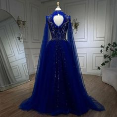 a blue dress with sequins on the back and long sleeves is displayed in front of a mirror