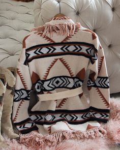 A stunning knit blanket sweater that is perfectly cozy for the season. Open front & soft fringe fold over collar. Color: Cream, camel & black Poly Hand wash cold Model is a size 8 wearing a medium. Small Medium Large Bust 50 52 53 Waist 49 51 52 Hips 51 53 54 Length 31 31 31 Bust, waist, and hip measurements are a total circumference. Length is measured from the top of the shirt to the hem. Measurements are an estimate. Beige Shawl Collar Sweater Coat For Fall, Chic Shawl Collar Sweater For Fall, Fall Tassel Long Sleeve Sweater, Beige Shawl Collar Sweater For Fall, Beige Bohemian Sweater For Fall, Bohemian Beige Sweater For Fall, Beige Long Sleeve Sweater With Fringe, Camel Long Sleeve Sweater For Fall, Long Sleeve Camel Sweater For Fall