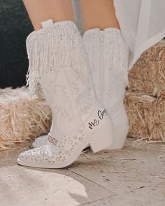 a close up of a person wearing white cowboy boots