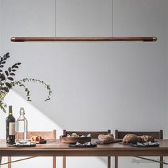 a wooden table topped with lots of food next to a vase filled with flowers and bottles