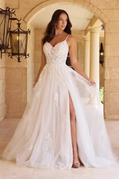 a woman in a white wedding dress posing for the camera