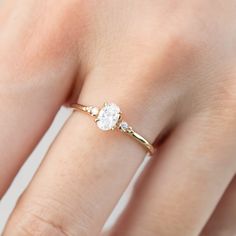 a woman's hand with a diamond ring on top of her finger and an engagement band