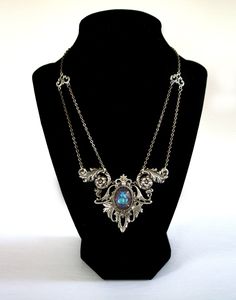 "Gothic Victorian necklace , elven necklace , Art Nouveau statement necklace with crystal , Edwardian necklace , Victorian necklace A unique, Gothic Victorian necklace that adds an elegant statment to any outift!  This Victorian Necklace features an 18 x 13 mm premium cut glass crystal. The crystal color in photos is the color \"Lagoon\" but you can choose your crystal color in the drop down menu (examples of other colors can be seen in the last photo). The crystal is set into gorgeous ornate detailed silver filigree with subtle art nouveau elements. Necklace is finished with antique silver soldered link chain that secures at the back with a lobster clasp. This statement necklace is bold yet very lightweight on the neck.  DETAILS * Chain is 14 inches long - necklace hangs higher on the nec Silver Gothic Necklaces For Fantasy Events, Fantasy Metal Pendant Necklace, Fantasy Pendant Jewelry For Fantasy Events, Fantasy Pendant Necklace For Fantasy Events, Elven Style Metal Jewelry For Gifts, Elven Style Metal Jewelry Gift, Silver Necklace For Fantasy Events, Elegant Silver Jewelry For Fantasy Events, Mystical Handmade Jewelry For Fantasy Events