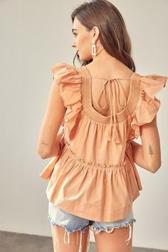 Final Sale - Get it before it's gone! Beautiful weather calls for the Dani Apricot Ruffle Babydoll Top! This flowy, woven top has a square neckline, short ruffle sleeves, and a wide-cut bodice. A relaxed silhouette features a ruffled trim drop seam tier with a ruffle hem. Tassel tie back finishes the look. Pair with your favorite shorts for a cute warm-weather look! DETAILS & CARE Cotton. Machine wash cold. Imported. Summer Peasant Top With Smocked Back And Square Neck, Summer Peasant Top With Square Neck And Smocked Back, Summer Square Neck Peasant Top With Smocked Back, Flowy Smocked Top With Square Neck For Spring, Spring Square Neck Flowy Smocked Top, Cotton Smocked Top With Flutter Sleeves For Spring, Flowy Square Neck Smocked Top For Spring, Summer Smocked Top With Ruffle Hem And Short Sleeves, Spring Smocked Top With Square Neck