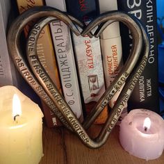 a heart shaped bookender sitting next to a candle