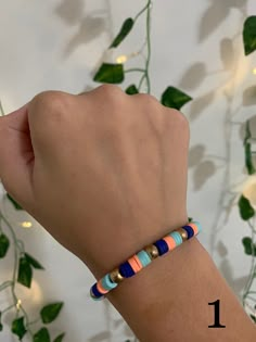 a woman's hand with a bracelet that has two different colored beads on it