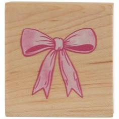 a wooden stamp with a pink bow on it