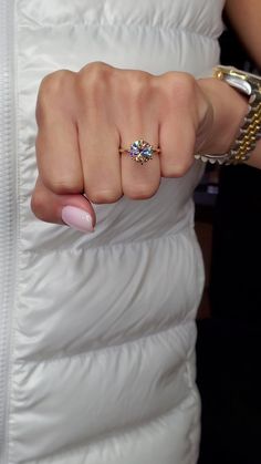 a woman in a white dress holding onto her finger with a gold ring on it