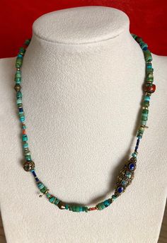 Eclectic Turquoise Necklace w/ handmade beads from Nepal. Largest bead is 1 1/4" x 3/8". Natural Vintage Inlaid Coral Bead. Common practice in Nepal was to fill the cracks and crevasses of old coral beads with bronze, turquoise, lapis and coral. These beads have become very rare and hard to find. Very unique necklace. I also mixed in a variety of other coral and brass beads. Brass Hook Clasp. Upon request I can custom make this necklace or any other necklace in my store longer. I will quote a pr Handmade Bohemian Turquoise Necklace With Oval Beads, Artisan Hand-strung Turquoise Necklace For Festivals, Artisan Beaded Turquoise Necklace, Handmade Turquoise Beaded Necklaces, Artisan Turquoise Necklace With Colorful Beads For Festivals, Traditional Handmade Turquoise Beaded Necklaces, Unique Handmade Turquoise Beaded Necklaces, Artisan Turquoise Necklace With Large Beads As A Gift, Handmade Blue-green Beaded Necklaces