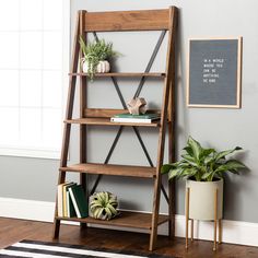 a wooden shelf with books and plants on it in a room next to a potted plant