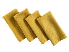 four pieces of yellow linen sitting on top of each other in front of a white background