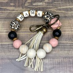 the personalized bracelet with tassels is shown on a wooden surface and has an animal print charm