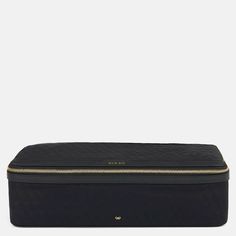 a black cosmetic bag with gold zippers on the front and side, sitting against a white background