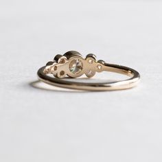 two gold rings sitting on top of each other, one with a diamond in the middle