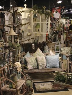 a living room filled with lots of furniture and decorating items in front of a window