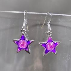 One of a kind hand painted (gradient purple blend) and resin (creates a glass like finish) dangling star earrings.  Embellished with embedded Austrian crystal (electric violet) star charms are silver plated pewter. Hung on sterling silver .925 stamped French ear wires.  Approximate length 1.25". Stars are for dreamers, doers and believers. The magic of possibilities is among the stars, in the heavens of our ideas and the wishes we keep or share with the world. Photos taken in studio light.  Free U.S. shipping on orders over $35. International shipping available. Same item as shown, contact me for free sizing adjustments. Shipped in a sealed and protected plastic bag. Free customer consultation offered to create a client profile I keep on hand with measurements and preferences for future or Purple Resin Jewelry With Matching Earrings, Purple Resin Jewelry For Party, Purple Resin Party Jewelry, Star-shaped Resin Jewelry For Gifts, Star Shaped Resin Jewelry Gift, Pink Star-shaped Sterling Silver Jewelry, Purple Resin Drop Earrings, Nickel-free Silver Resin Earrings, Handmade Purple Resin Jewelry