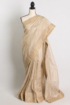 Elevate your ethnic wardrobe with this stunning Semi Tissue Designer Partywear Saree in Light Brown. The saree is beautifully crafted with intricate golden stitched border, adding a touch of elegance to the overall look. The light brown color exudes a modern yet traditional vibe, making it perfect for any festive occasion or party. Pair it with statement jewelry and a stylish blouse to make a head-turning entrance at any event. Color : Brown and Gold.    Blouse Piece : Yes ( cut and separated from the saree ). Fall Pico : Yes.  Care: Dry-Clean Only. Elegant Resham Embroidered Slub Silk Pre-draped Saree, Elegant Slub Silk Pre-draped Saree With Resham Embroidery, Cotton Silk Blouse Piece With Dupatta For Eid, Festive Chanderi Pre-draped Saree For Celebration, Cotton Silk Pre-draped Saree With Zari Work For Celebration, Celebration Cotton Silk Saree With Zari Work, Gold Anarkali Style Cotton Silk Pre-draped Saree, Celebration Cotton Silk Pre-draped Saree With Zari Work, Traditional Slub Silk Pre-draped Saree For Celebration