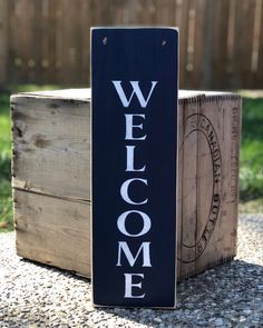 a welcome sign sitting on top of a wooden crate