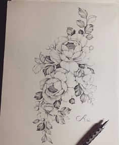 a pencil drawing of flowers and leaves on a sheet of paper with a pen next to it