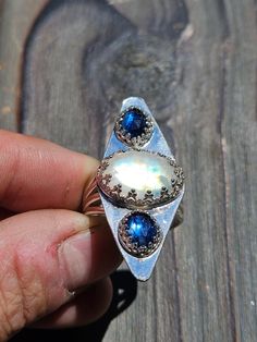 This statement piece is Indian Moonstone and Brazilian blue kyanite! Such a beauty, sterling silver, size 8 with a quad-split band! Blue Moonstone Ring With Accent Stones, Unique Blue Moonstone Cabochon Ring, Unique Blue Cabochon Moonstone Ring, Blue Oval Moonstone Ring, Unique Moonstone Ring With Accent Stones In Sterling Silver, Unique Blue Labradorite Ring, Blue Labradorite Moonstone Ring, One-of-a-kind Oval Moonstone Ring In Sterling Silver, Blue Moonstone Ring With Natural Stones