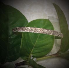 MAKE SURE OF THE SIZE BEFORE ORDERING. 5mm gold filled Hawaiian bangle, 1.70mm thickness. Personalize it with a name or a message engraved and enameled in black. The pattern of plumerias and Victorian scrolls are rolled on a 5mm barrel gold filled wire. All the characters are engraved , not stamped, resulting in straight and aligned name. A black enamel is used to fill in the characters engraved. The maximum number of letters is 15. How Gold filled is made. Gold filled or gold overlay is made by Adjustable Heirloom Hallmarked Bangle, Classic Adjustable Etched Bangle, Classic Engraved Adjustable Bangle, Adjustable Etched Bracelets For Anniversary, Adjustable Engraved White Gold Bangle, Engraved White Gold Bangle For Anniversary, Engraved White Gold Cuff Bracelet, Adjustable Etched Gold Bangle, Adjustable Gold Etched Bangle