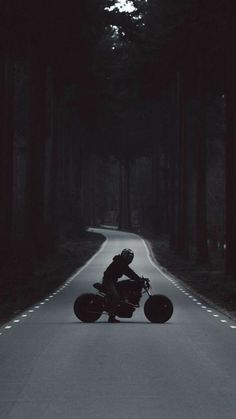 a person riding a motorcycle down a dark road