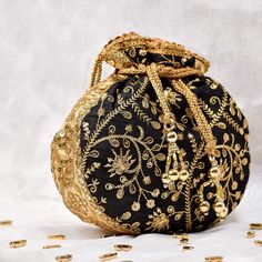 Black Potli Bag with Pearl Handle Strap With its classy zari work and a pearl handle strap all in gold this Black Potli Bag is ideal for this wedding season. Fabric Raw Silk Color Black Embroidery Zari Work in Gold Size amp Dimensions Height - 8 inWidth - 7.5 inDepth - 1.5 in Strap Pearl Handle Strap Closure Tasseled Drawstring Compartments Single compartment Care Wipe with a soft clean amp dry cloth to remove dust When not in use store it in a dust bag for longer product life Avoid liquid expos Handmade Gold Potli Bag For Party, Handmade Potli Bag For Party And Festivals, Bohemian Gold Bags With Latkans, Gold Shoulder Bag With Handwork For Festivals, Bohemian Embroidered Gold Evening Bag, Bohemian Gold Embroidered Evening Bag, Bollywood Style Gold Festive Shoulder Bag, Gold Festive Clutch For Festivals, Gold Potli Bag With Zari Work For Evening