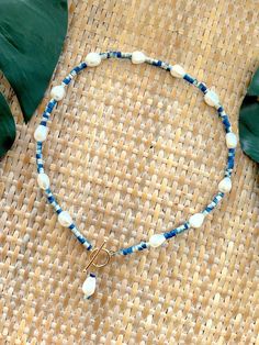 Welcome to our Coastal Inspired Beaded Pearl Necklace – a stunning blend of elegance and coastal charm, inspired by the breathtaking coastline of Santorini, Greece! 🌊✨Crafted with care and attention to detail, this necklace features a beautiful combination of unique tie-dyed bright blue and white coconut shell heishi beads, reminiscent of the colors of the Aegean Sea, and lustrous 9mm freshwater pearls. Each bead is carefully selected to evoke the serene beauty of Santorini's coastline, creatin Ocean-inspired Beaded Jewelry, Bohemian Blue Strand Jewelry, Blue Bohemian Strand Jewelry, Ocean-inspired Blue Strand Jewelry, Blue Ocean-inspired Strand Jewelry, Handmade Blue Strand Jewelry, Blue Strand Necklace With Ocean-inspired Style, Bohemian Pearl Charm Necklace For Vacation, Bohemian Necklace With Pearl Charm For Vacation