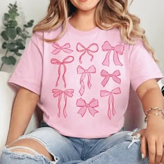 Introducing our Coquette Bow Graphic Tee – a charming addition to your casual wardrobe. This pink-colored, short-sleeve tee features a delicate bow graphic, adding a touch of elegance and femininity to your everyday style. *Will Ship in 3-5 Days* Size Suggestions: Small: 2-4 Medium: 6-8 Large: 10-12 XL: 14-16 2XL: 18-20 3XL: 22-24 Fabric Content: 52% Cotton 48% Polyester Care Instructions: Machine wash, cold. Tumble dry, low. Do not iron decoration. SKU: #242587 Cute Bow T-shirt For Spring, Cute Pink T-shirt With Bow, Feminine Pink Crew Neck T-shirt, Trendy Bow Print Tops For Spring, Cute Pink Short Sleeve T-shirt, Trendy Summer Tops With Pink Bow, Summer Bow Print Short Sleeve Tops, Summer Short Sleeve Tops With Bow Print, Summer Crew Neck T-shirt With Bow Print