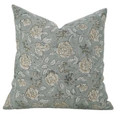 a gray pillow with flowers and leaves on it