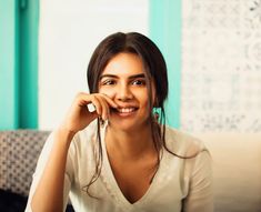 a woman sitting on top of a couch smiling