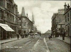 an old black and white photo of people walking down the street