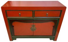 an orange and green cabinet with two doors on the front, one door open to reveal a drawer