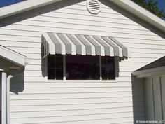 an awning on the side of a white house