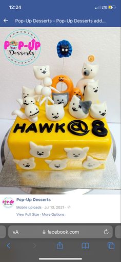 a yellow cake with white cats on it and the words pop up desserts written in black