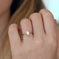 a close up of a person's hand wearing a gold ring with a diamond