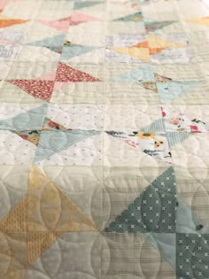 an old quilt is laying on top of a tablecloth that has been made into a star pattern