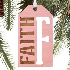 a wooden ornament with the word faith on it hanging from a christmas tree