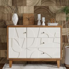 a white cabinet with drawers and vases sitting on it's sideboard in front of a wood paneled wall