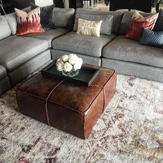 a living room with a large sectional couch and coffee table