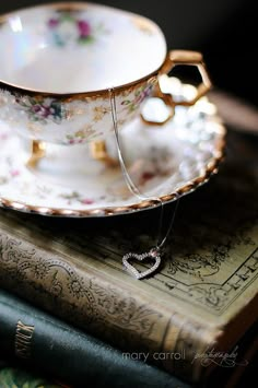 a tea cup and saucer sitting on top of two books