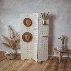 a hat rack with two hats on it next to a chair and potted plant