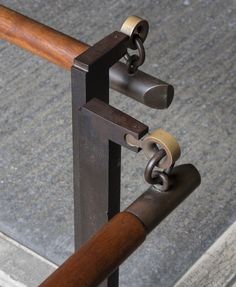 an iron and wood railing with two locks on each end, in front of concrete steps