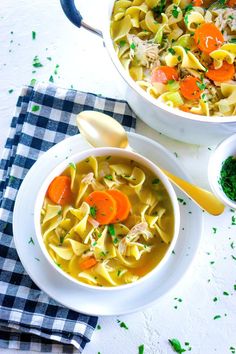 two bowls of chicken noodle soup on a table